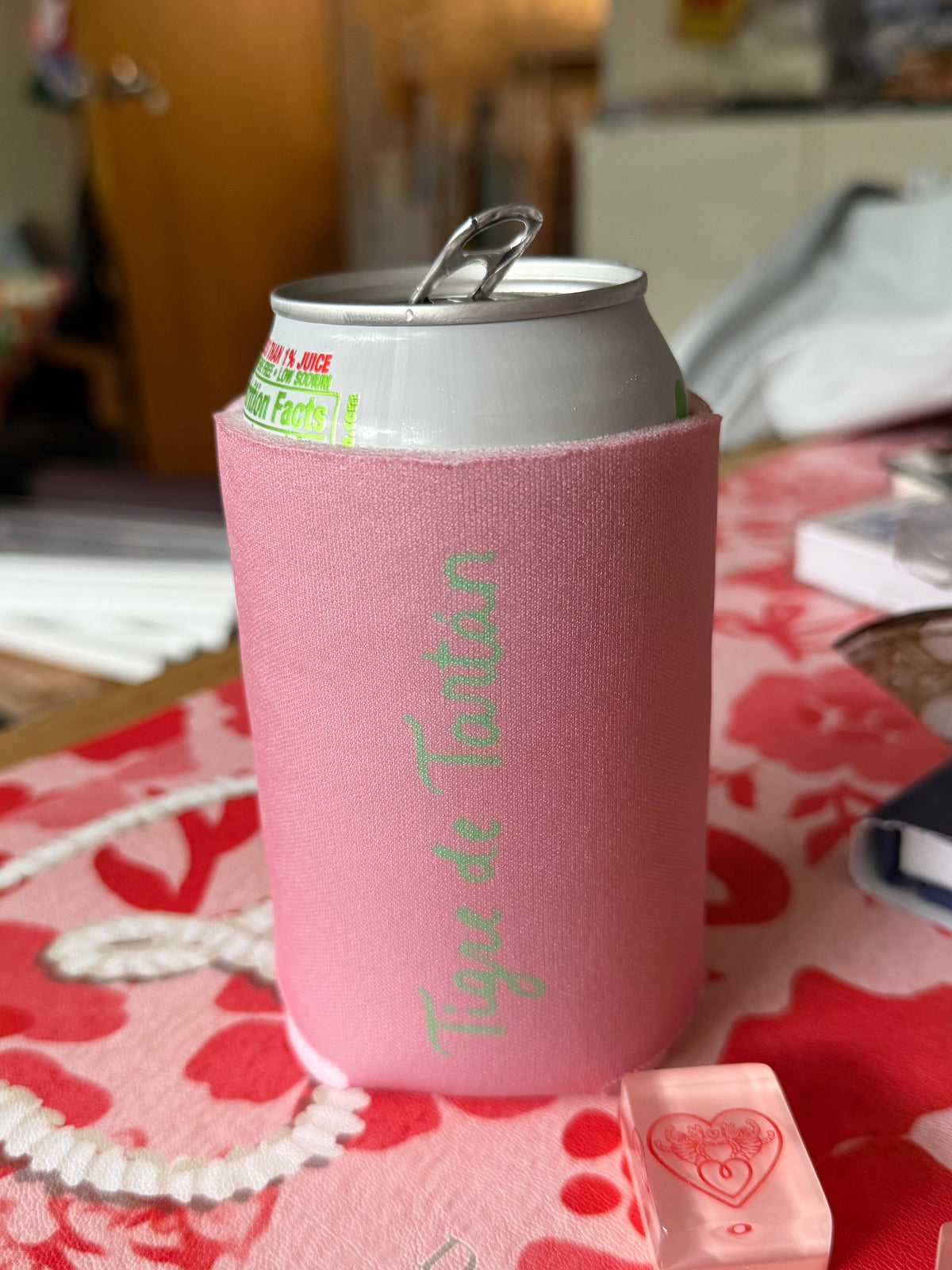 Side view of the pink Tiger Heart can koozie on a can, standing on a pink and red floral mahjong mat