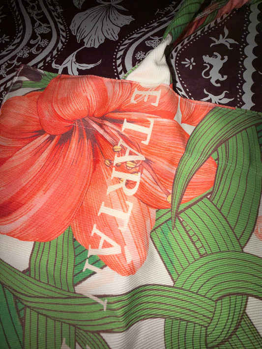Close-up of an amaryllis bloom, green trellis and Tigre de Tartán lettering on the Estate Sale denim tote