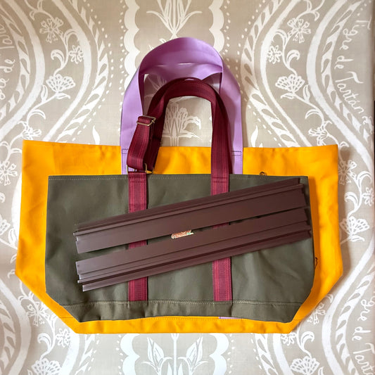 Marigold Signature XL Canvas Tote with a smaller olive canvas tote and wooden mahjong racks laid on top to show scale