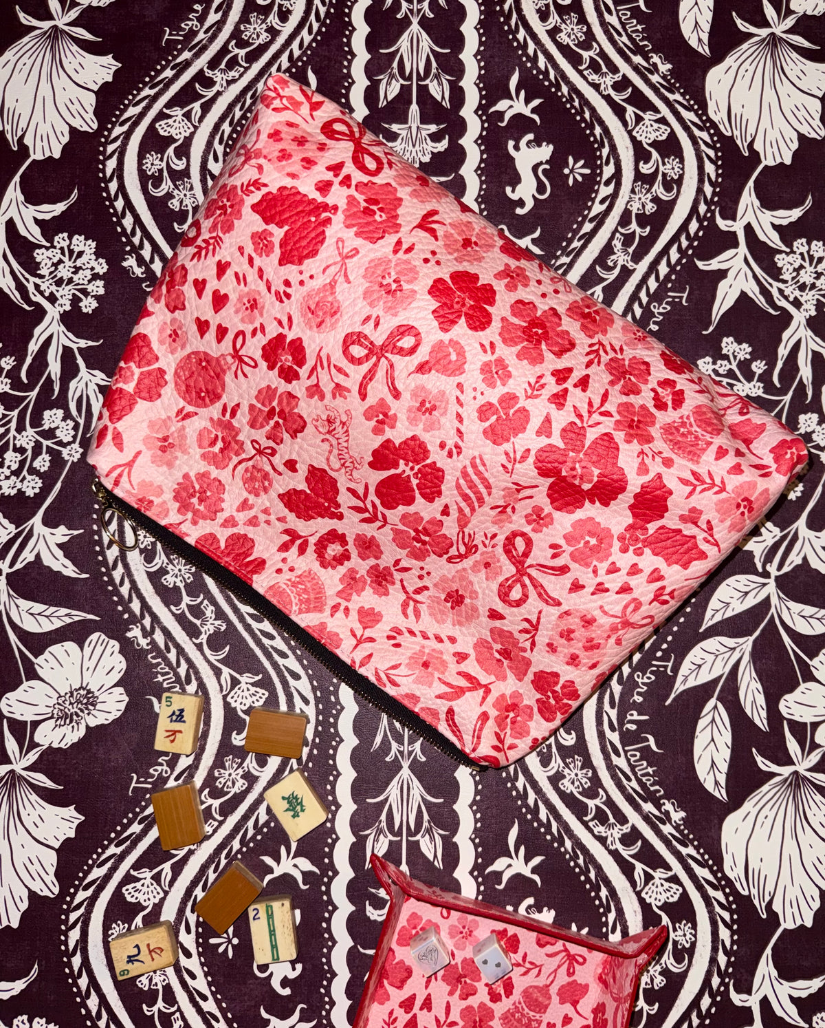 Ditsy Christmas MARASCHINO leather pouch beside mahjong tiles and a matching print tray on a dark floral background