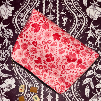 Generous leather pouch in the red and pink Ditsy Christmas MARASCHINO print with mahjong tiles on a dark floral background