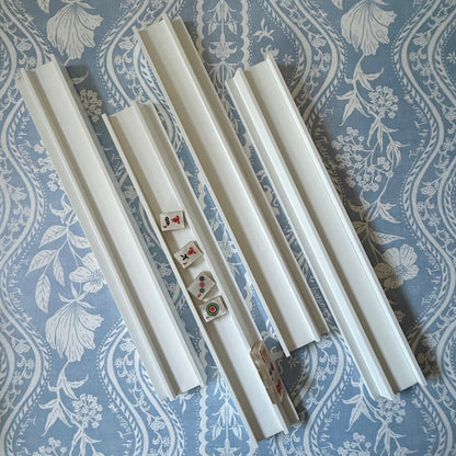 Four dove white racks, one holding tiles, on a blue and white floral fabric