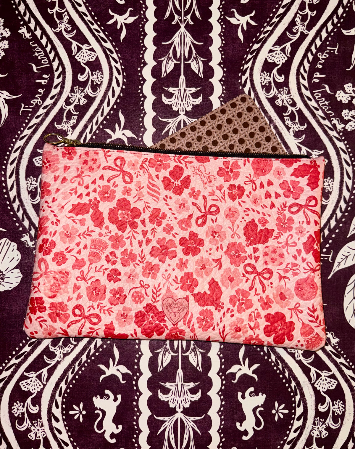 MARASCHINO medium leather pouch laid flat on a dark floral background