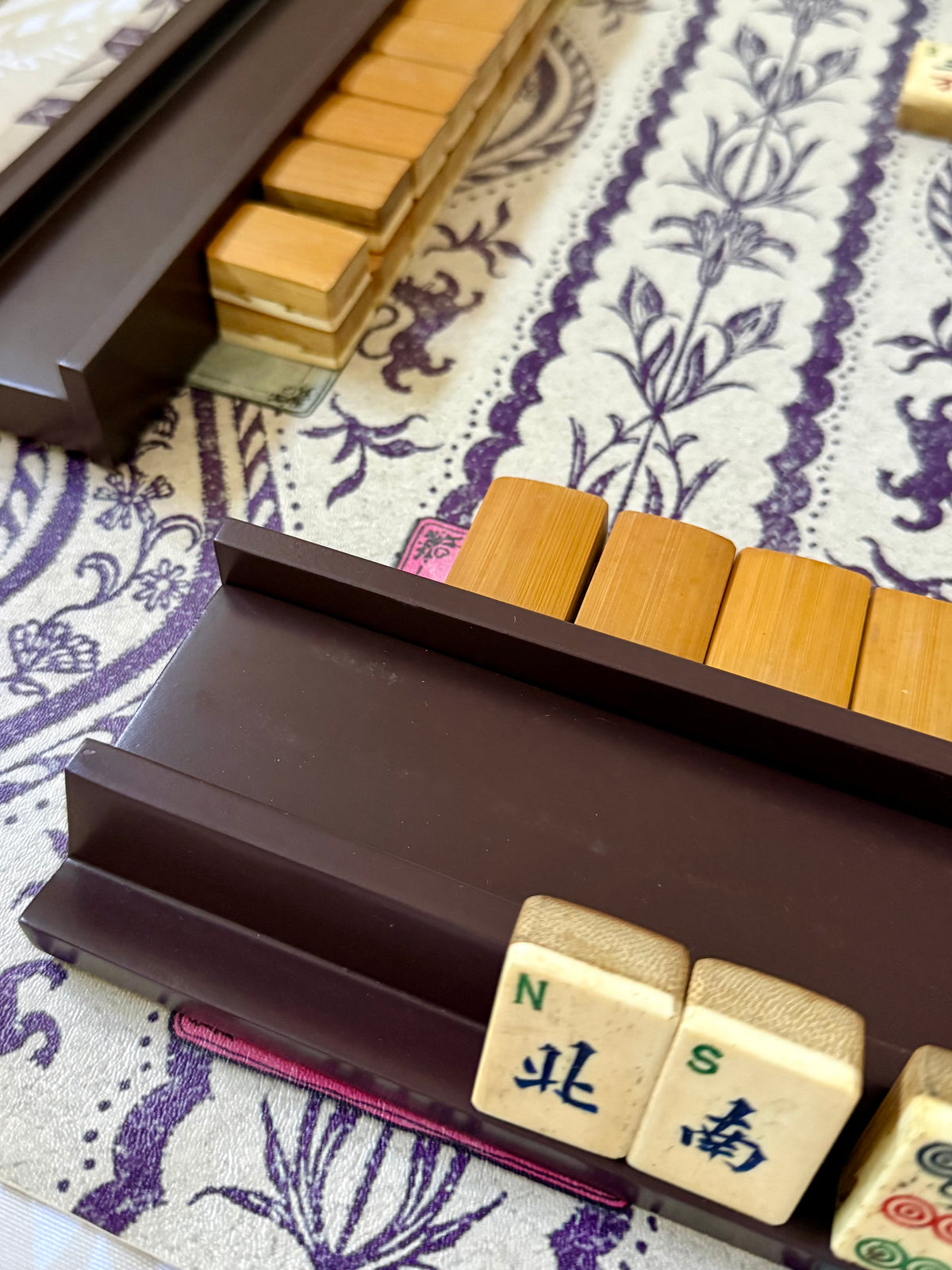 Rich raisin rack holding wind tiles in front of a wall of wooden tiles