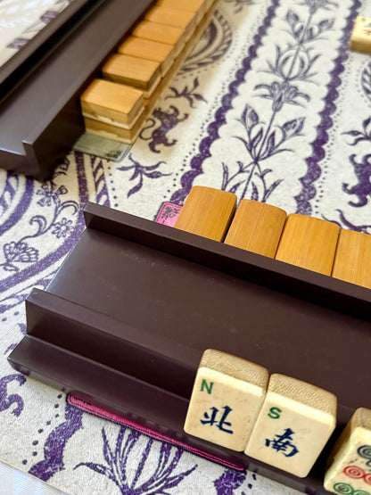 Rich raisin rack holding wind tiles in front of a wall of wooden tiles