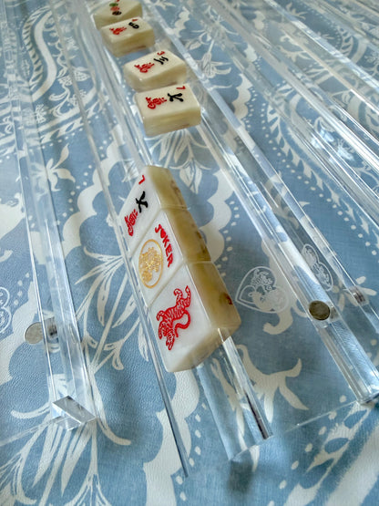 Clear acrylic racks holding cream tiles on blue and white fabric