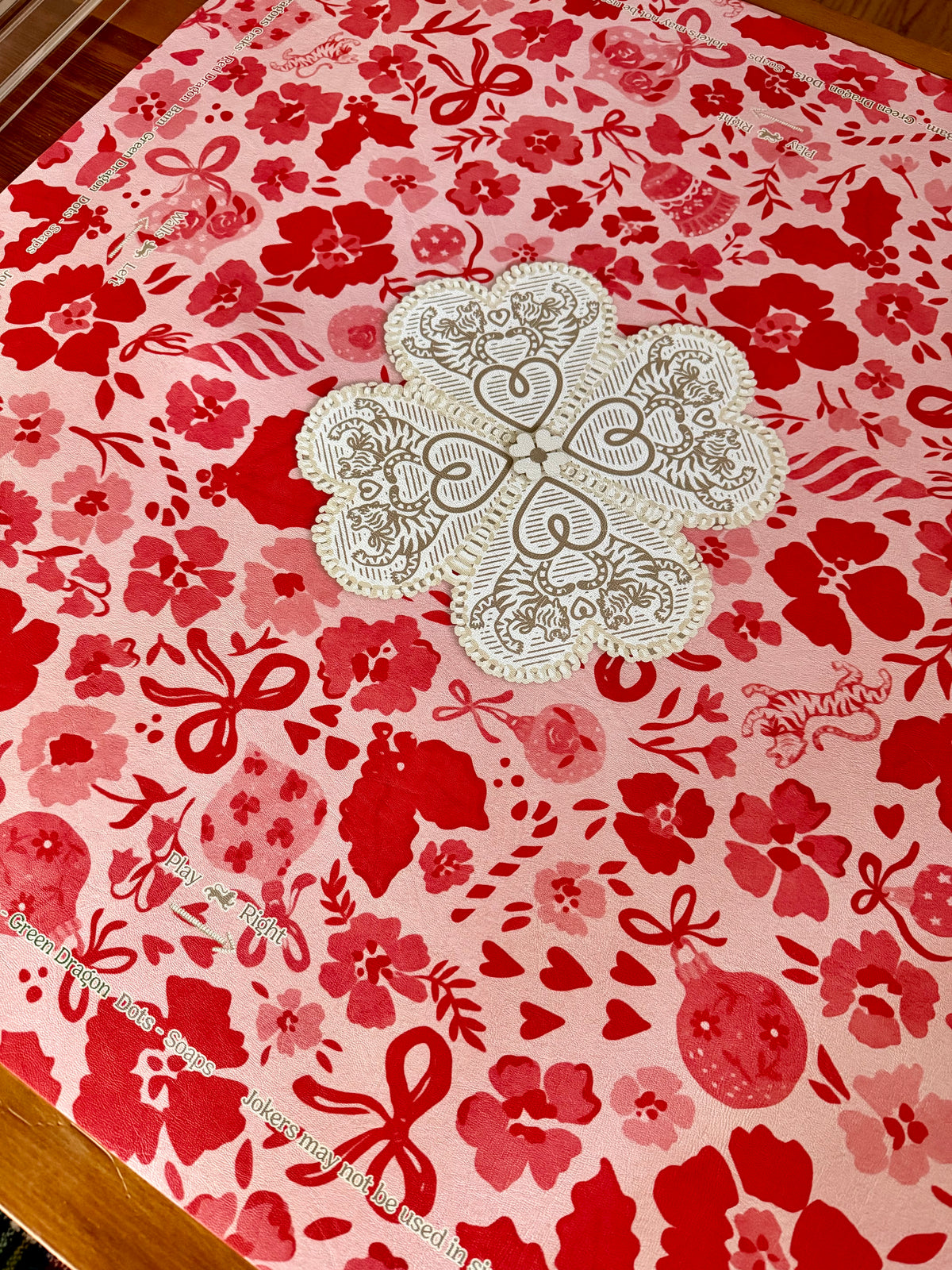 MARASCHINO mahjong mat on a wooden table with its cream lace-heart center medallion