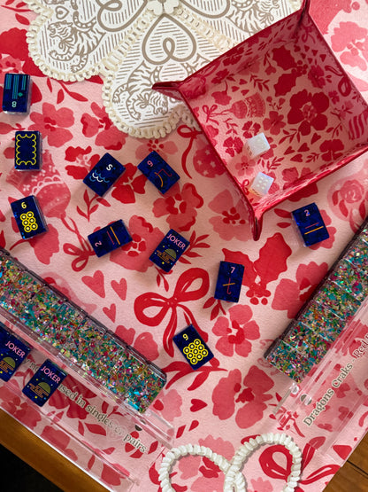 Navy tiles, a pink dice tray and glitter racks on the red floral MARASCHINO mat