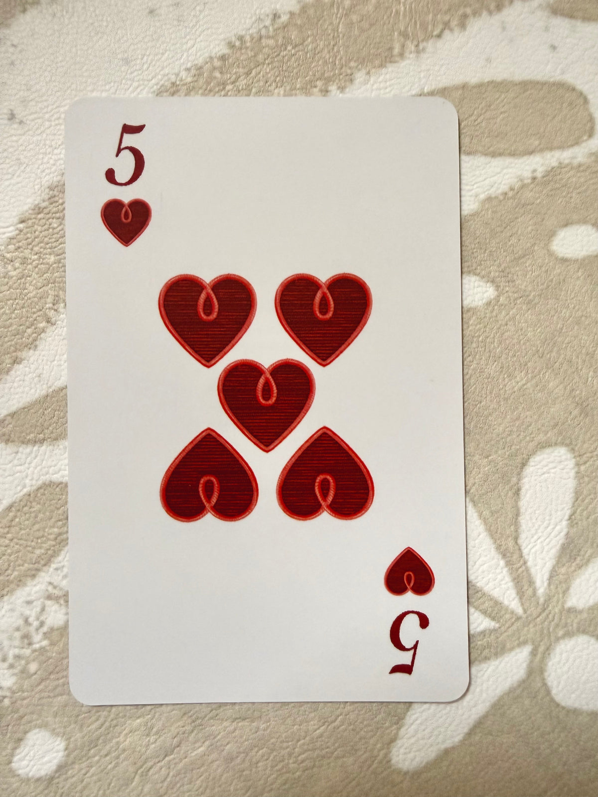Five of hearts from the Jardín de Los Jefes deck with faux-stitched red heart pips