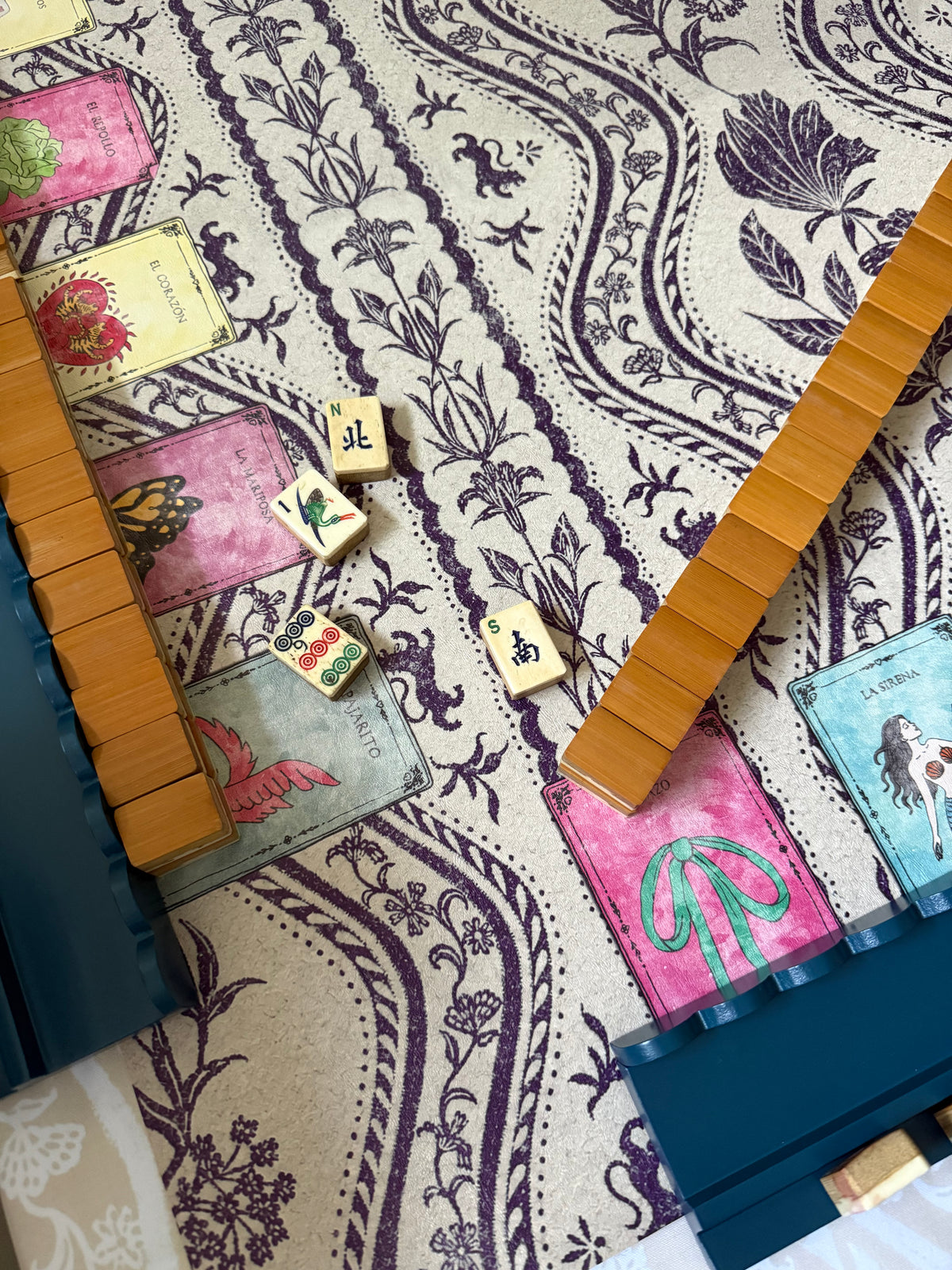 Marine blue rack with wooden tiles on a purple paisley card-print mat
