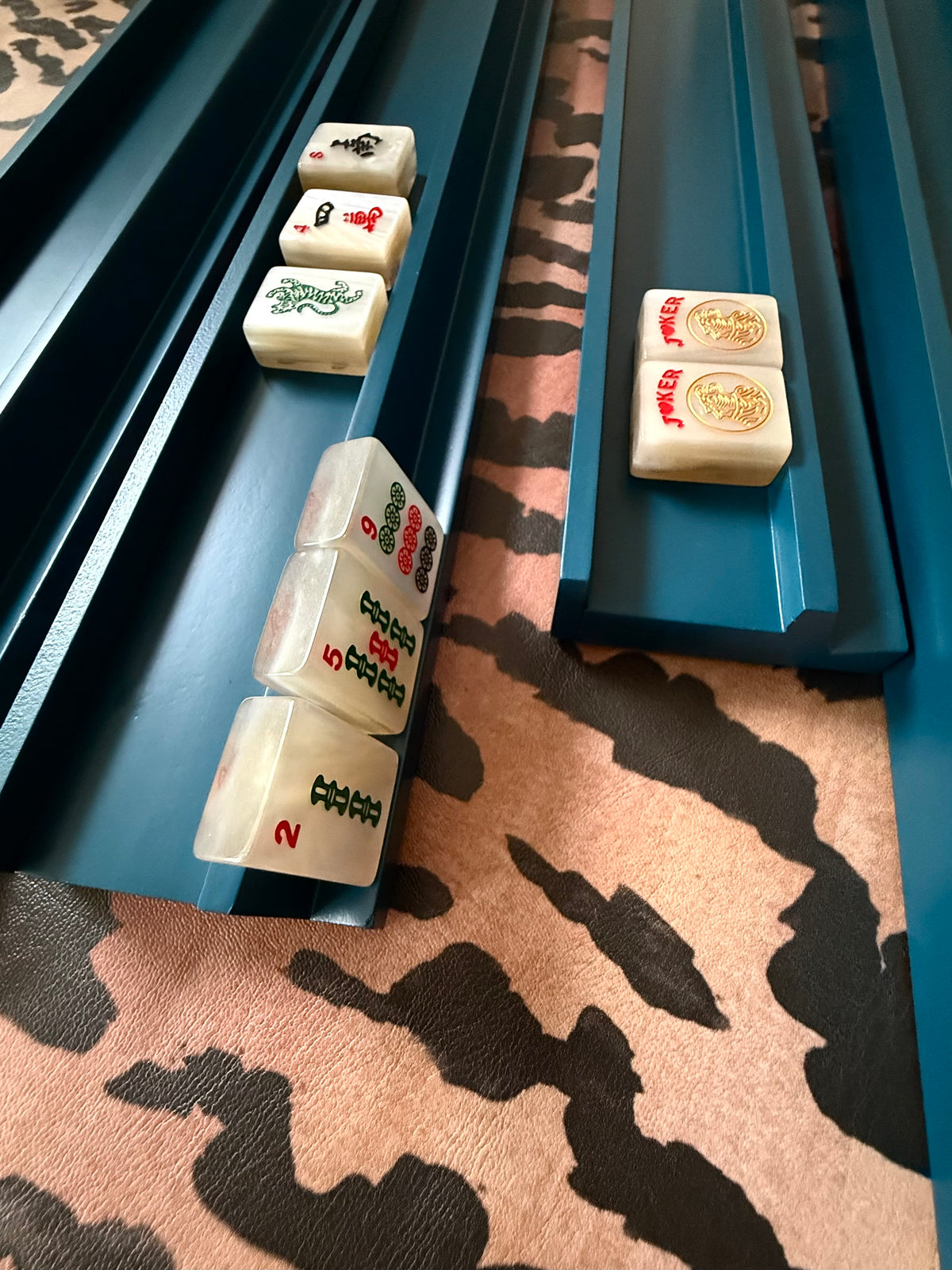 Marine blue straight racks holding cream tiles on tiger-stripe fabric