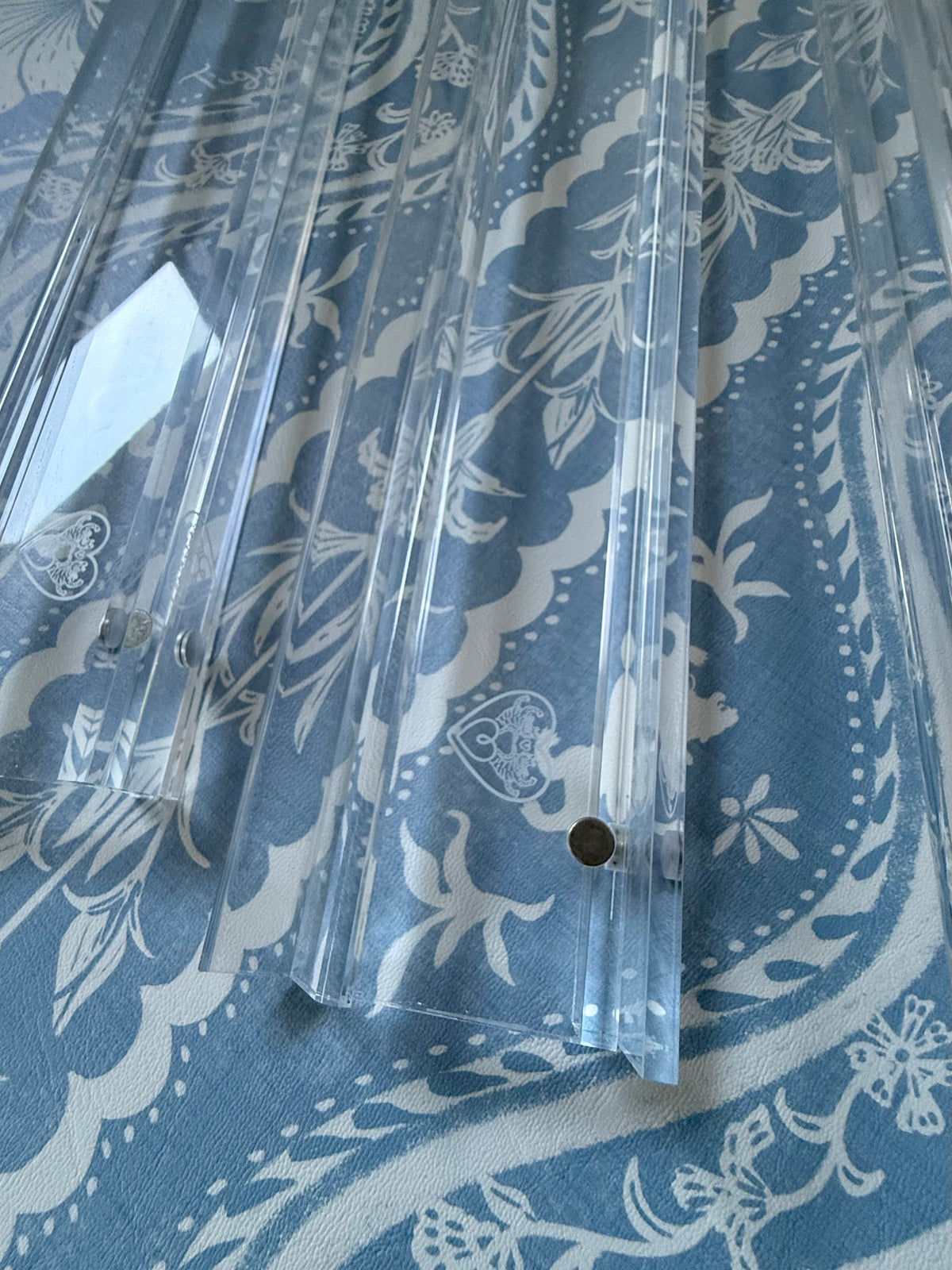 Close-up of clear acrylic racks showing the etched heart logo and magnet points