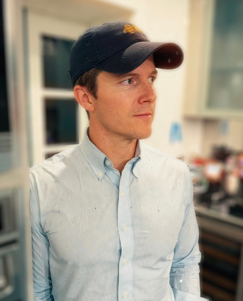 Man in a light blue shirt wearing the navy Tigre de Tartán logo cap