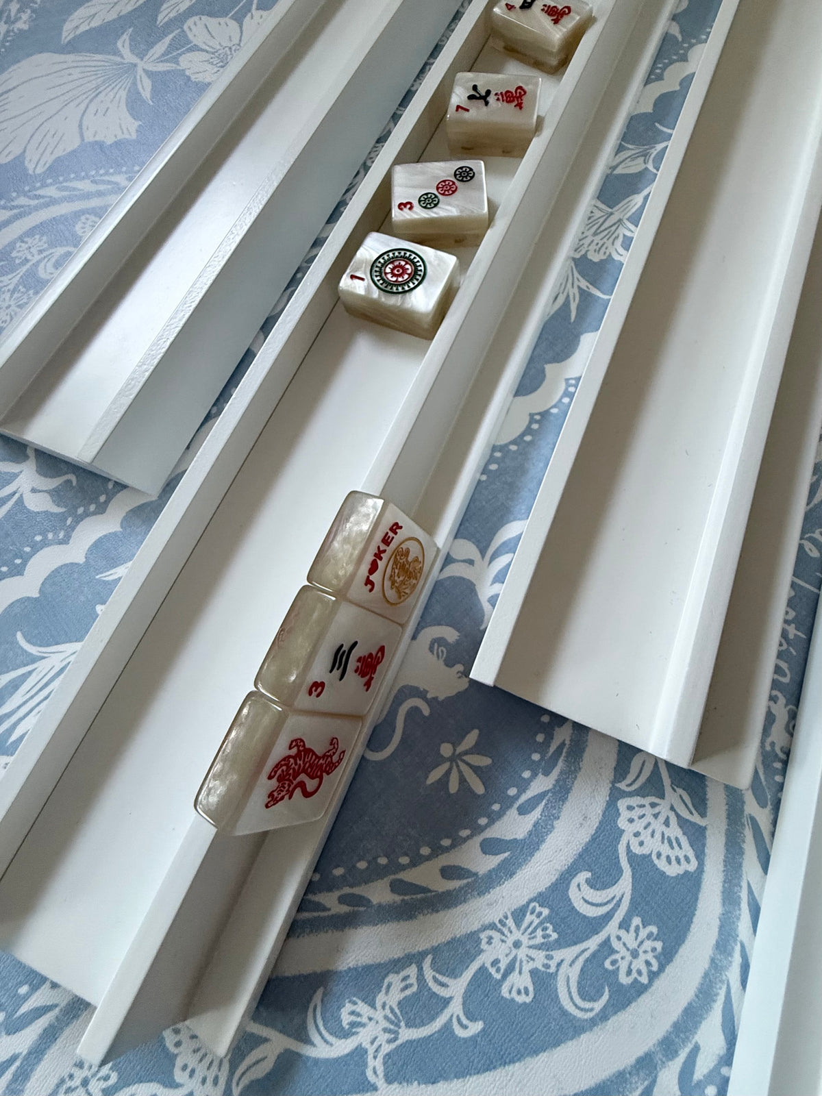 Dove white rack holding cream tiles on blue and white fabric