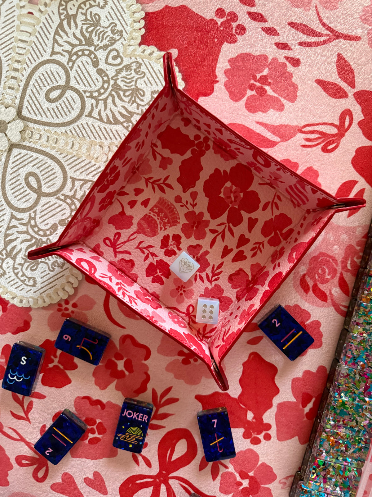 Ditsy Christmas MARASCHINO leather snap tray holding dice, with navy tiles on the matching mat