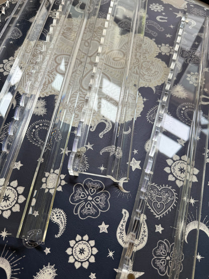 Empty clear acrylic racks with scalloped edges on a navy bandana-print mat