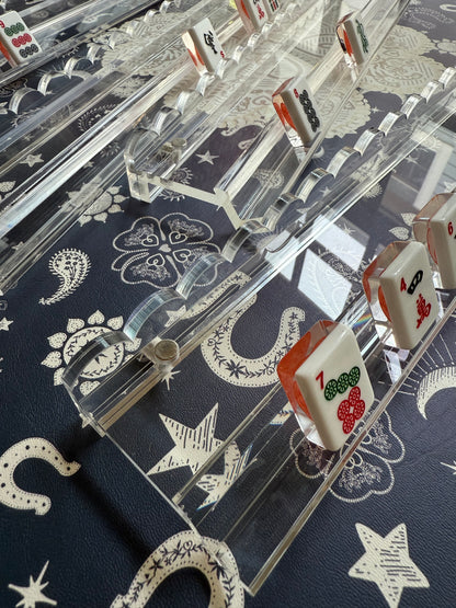 Tiles standing in clear scalloped acrylic racks on a navy mat with cream stars and horseshoes
