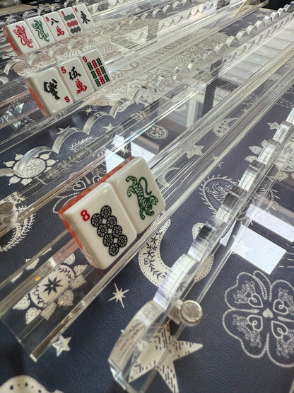 Clear scalloped acrylic racks holding tiles on a navy celestial-print mahjong mat