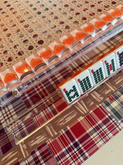 Clear acrylic rack holding heart and bamboo tiles on a cane-pattern mat with plaid border