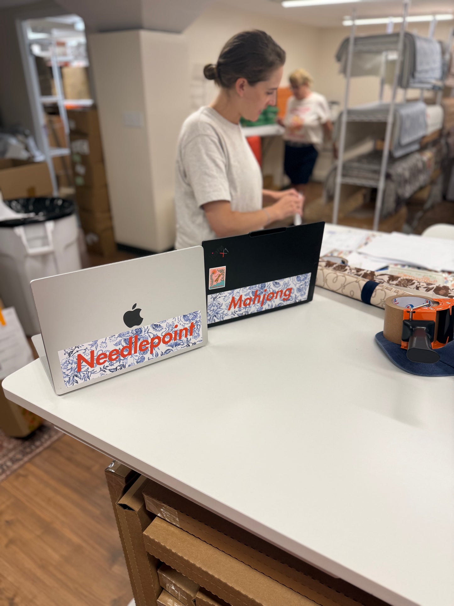 Two laptops, one with the Mahjong bumper sticker and one with the Needlepoint bumper sticker applied