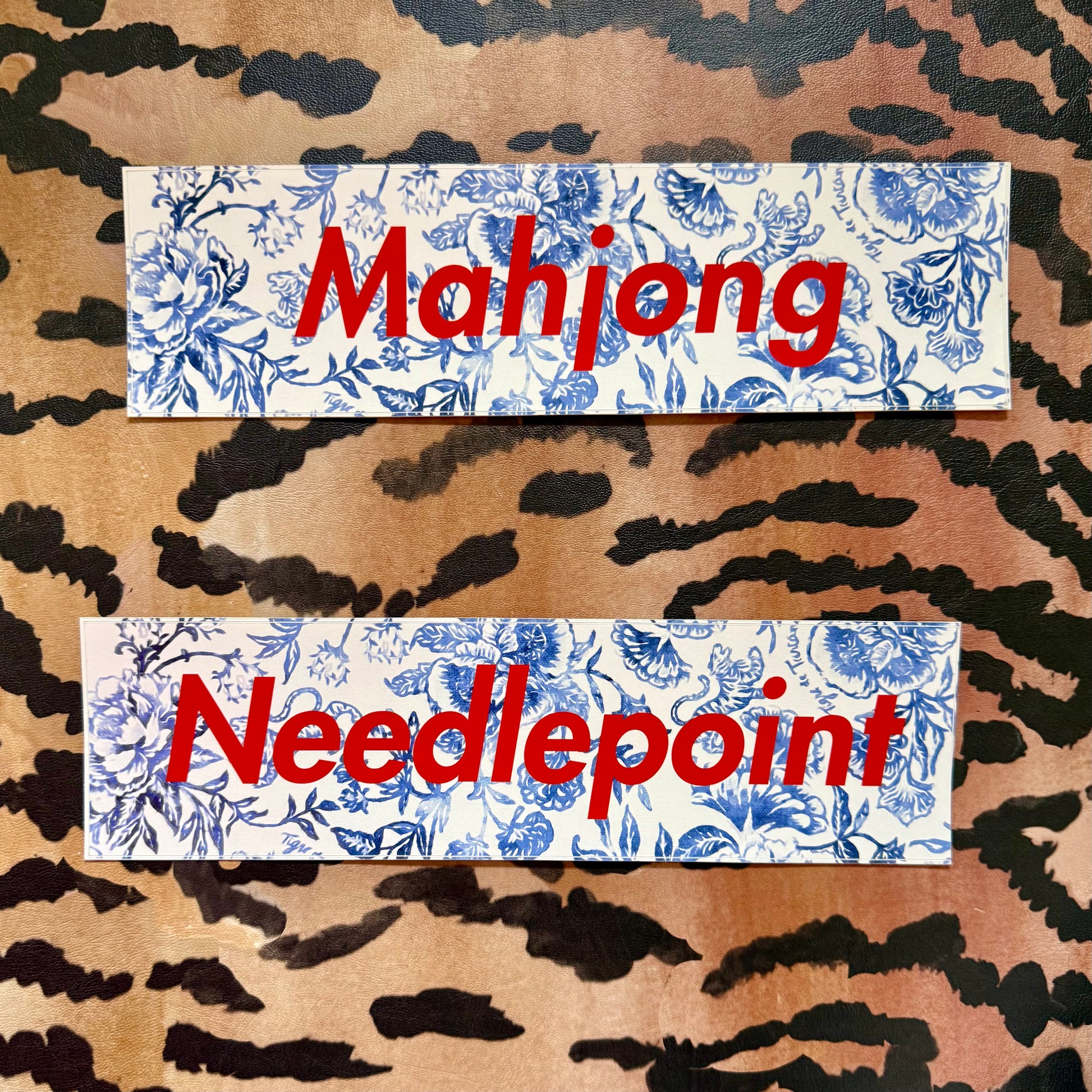 Mahjong and Needlepoint bumper stickers, blue-and-white floral with red lettering, on a tiger stripe background