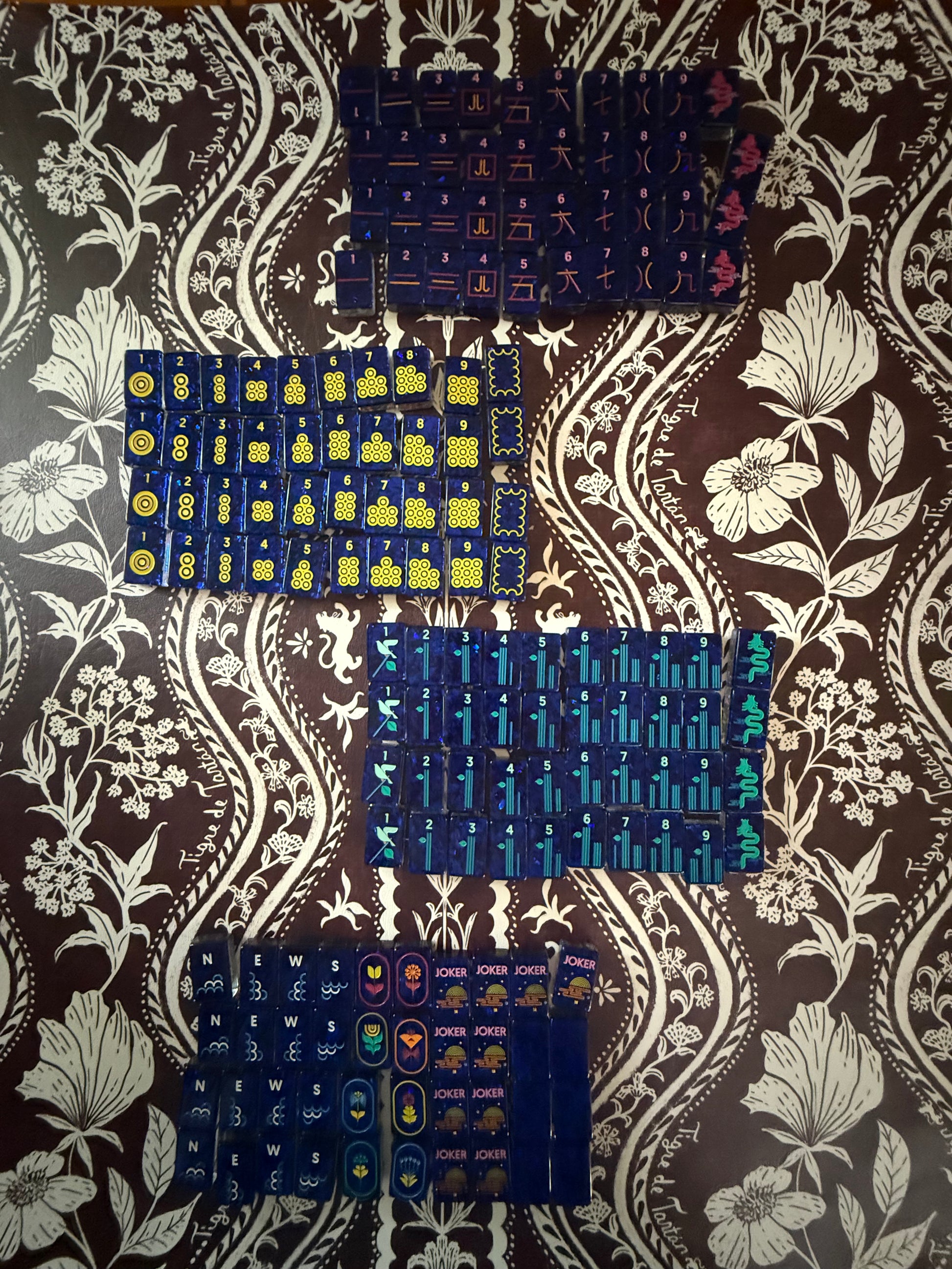 Mahj Pit Confetti mahjong tiles, large size, laid face-up on a mahjong mat showing the iridescent confetti finish and blue tile faces