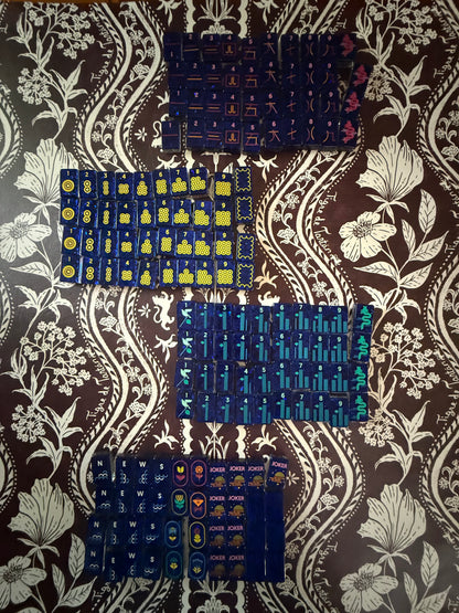 Mahj Pit Confetti mahjong tiles, large size, laid face-up on a mahjong mat showing the iridescent confetti finish and blue tile faces