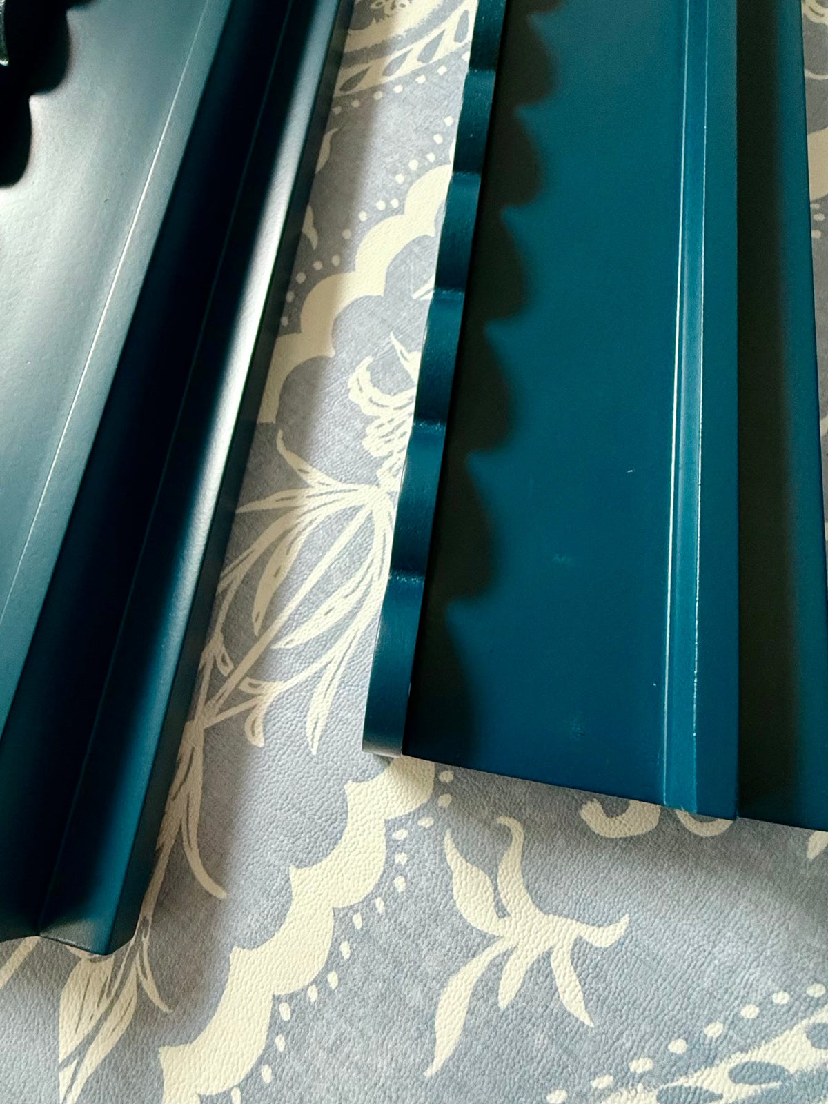 Close-up of the scalloped pusher edge on marine blue painted beech wood racks