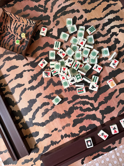 Mahjong tiles scattered across the El Tigre tiger stripe mat beside a dark wood rack