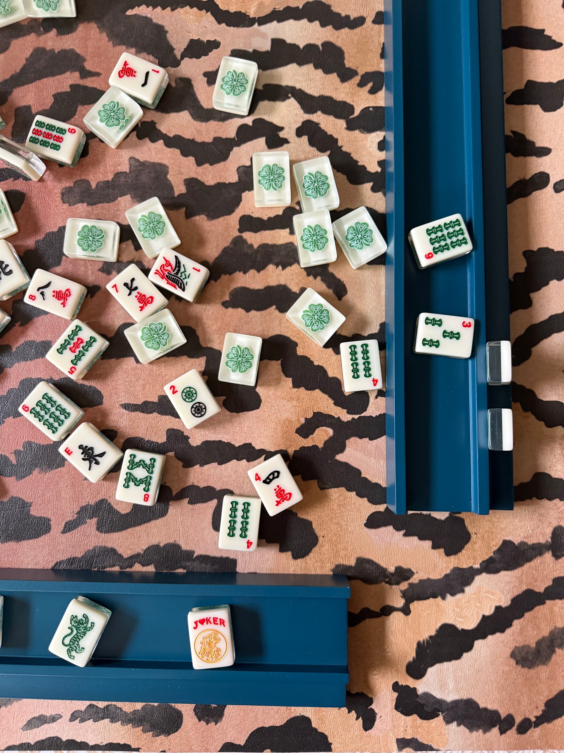 Mahjong tiles and a navy rack on the borderless El Tigre tiger stripe mat