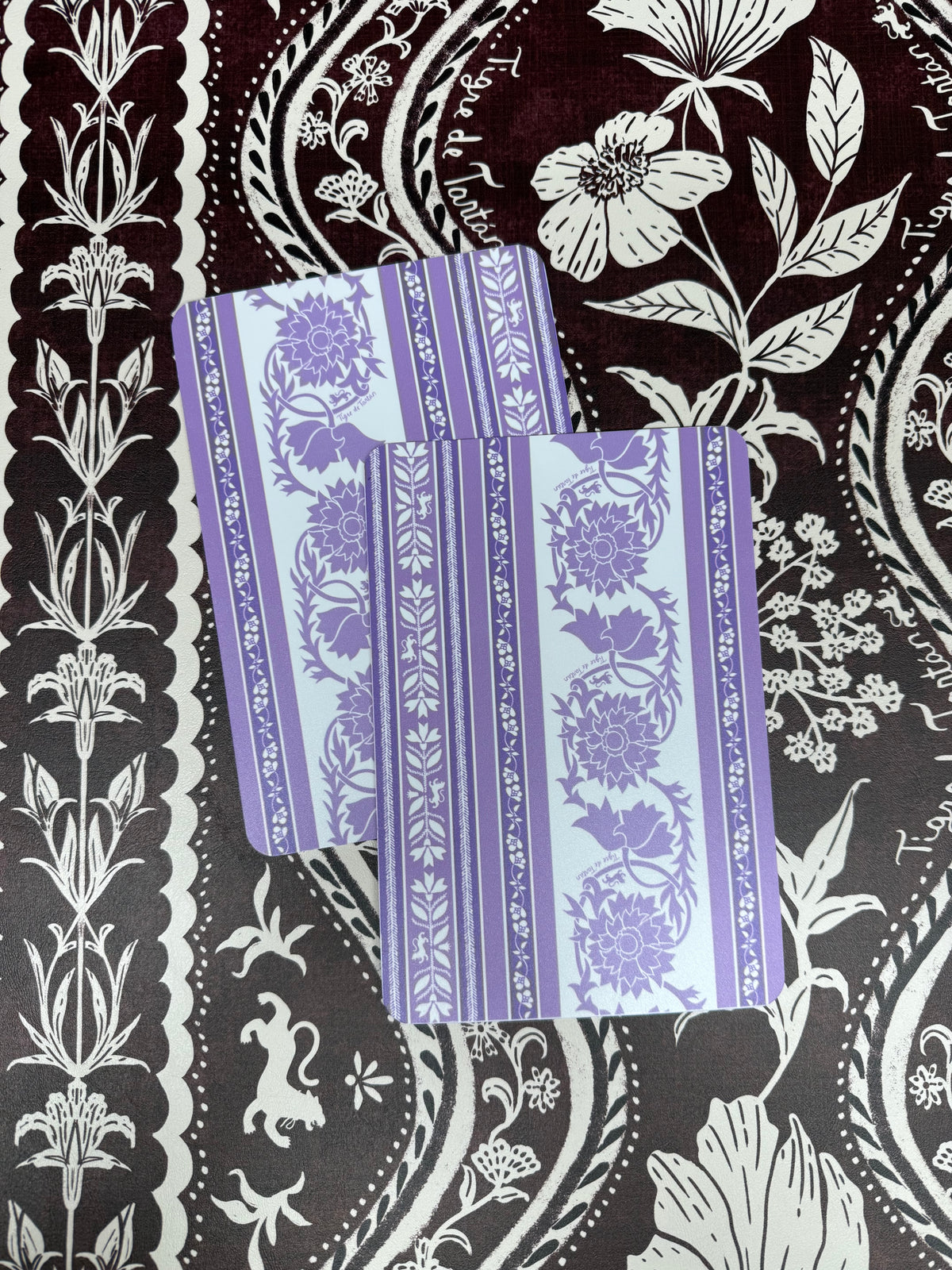Two lavender and white Thorn-print mahjong tile shufflers with floral vine stripes, on a dark plum and white botanical print