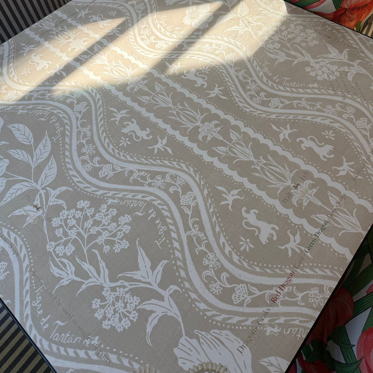 Domino Blonde mahjong mat in afternoon light, showing the cream and taupe botanical ribbon pattern