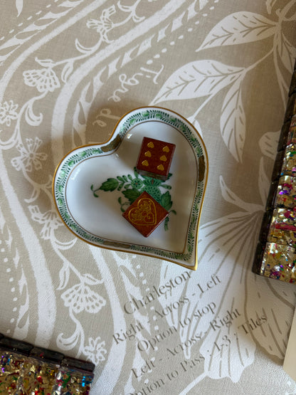Close-up of the printed Charleston rules along the edge of the Domino Blonde mat, with a heart-shaped dish holding two tiles