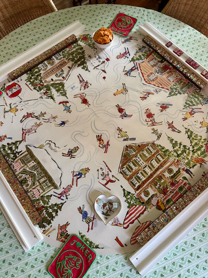 Après Mahj alpine village mahjong mat set on a round table with beaded racks, a heart-shaped dish and a red tin, from above