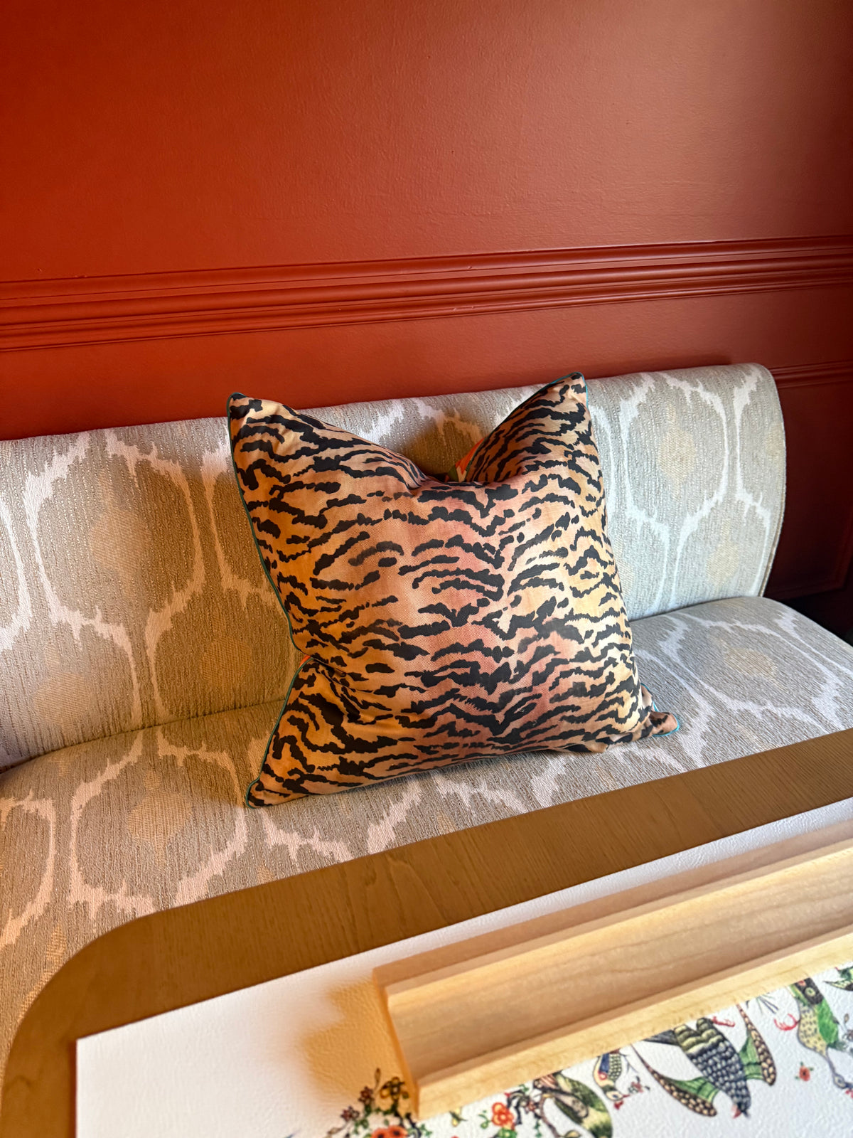 The reverse of the Estate Sale pillow in the El Tigre tiger-stripe linen, on a grey banquette