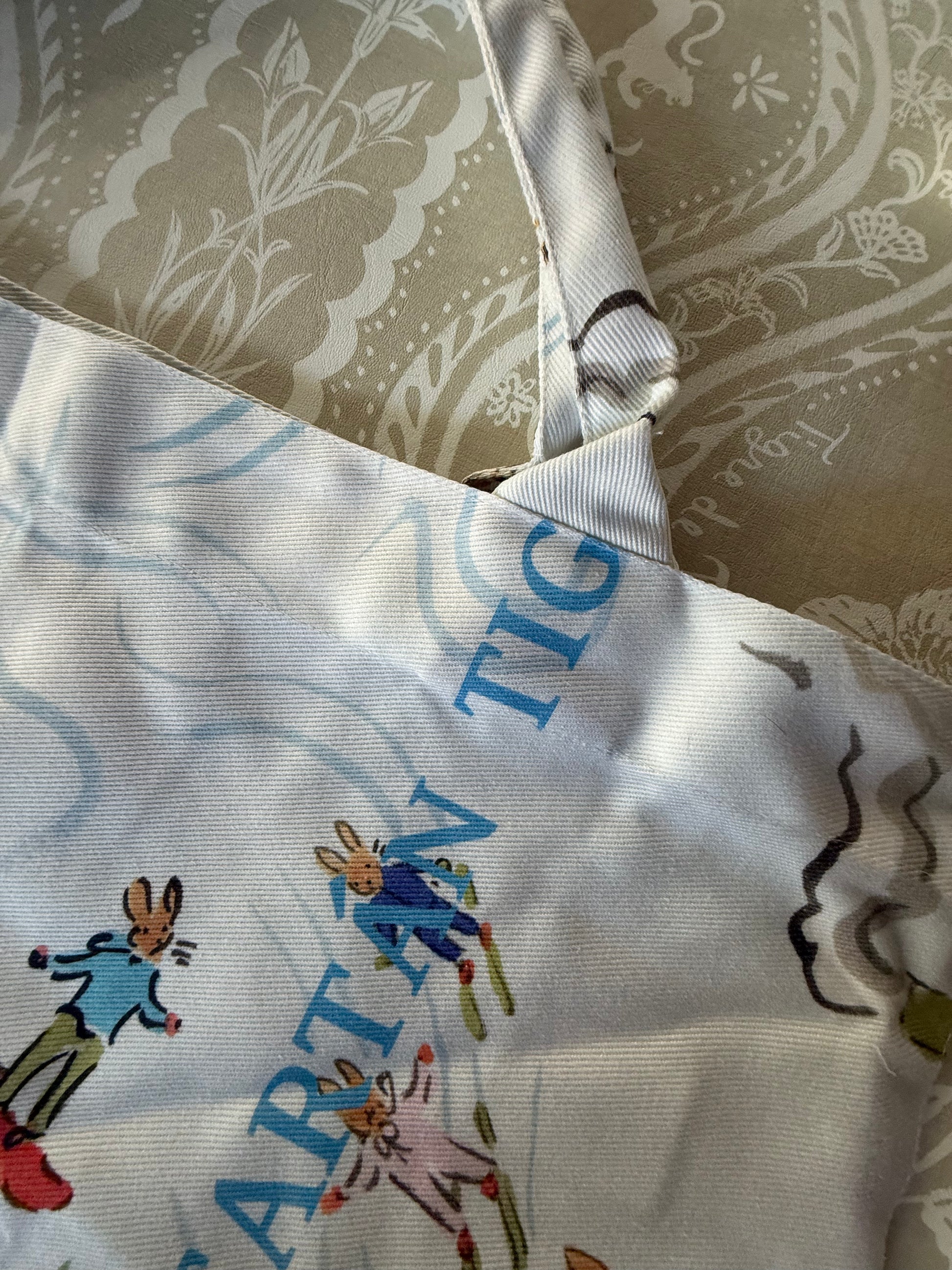 Close-up of the Après Mahj print on the tote: skiing rabbits and blue Tigre de Tartán lettering