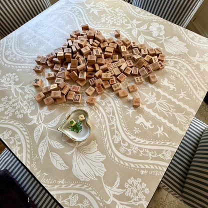 Domino Blonde mahjong mat on a card table with a pile of wooden tiles face down and a heart-shaped dish, from above