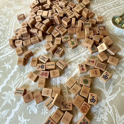 Wooden mahjong tiles scattered face up across the cream and taupe Domino Blonde mat