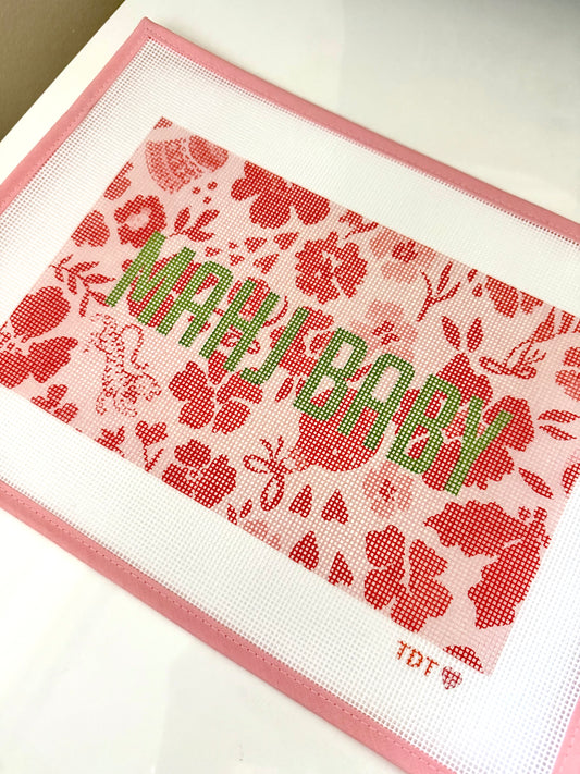 Mahj Baby printed needlepoint canvas in the Ditsy Christmas Maraschino print, pink and red florals with green lettering, angled view