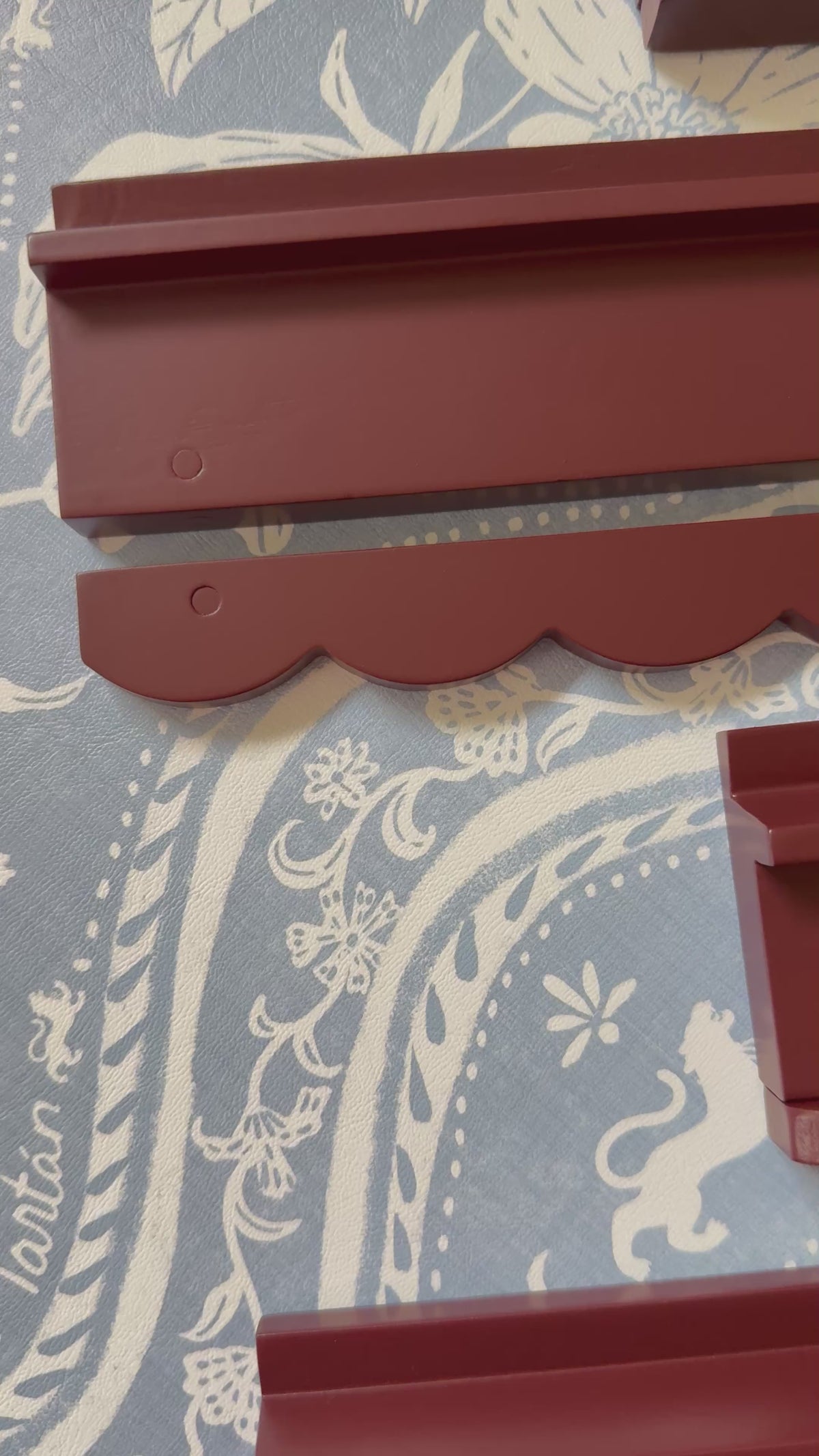 Video of oxblood wooden mahjong racks with scalloped pushers on blue and white fabric