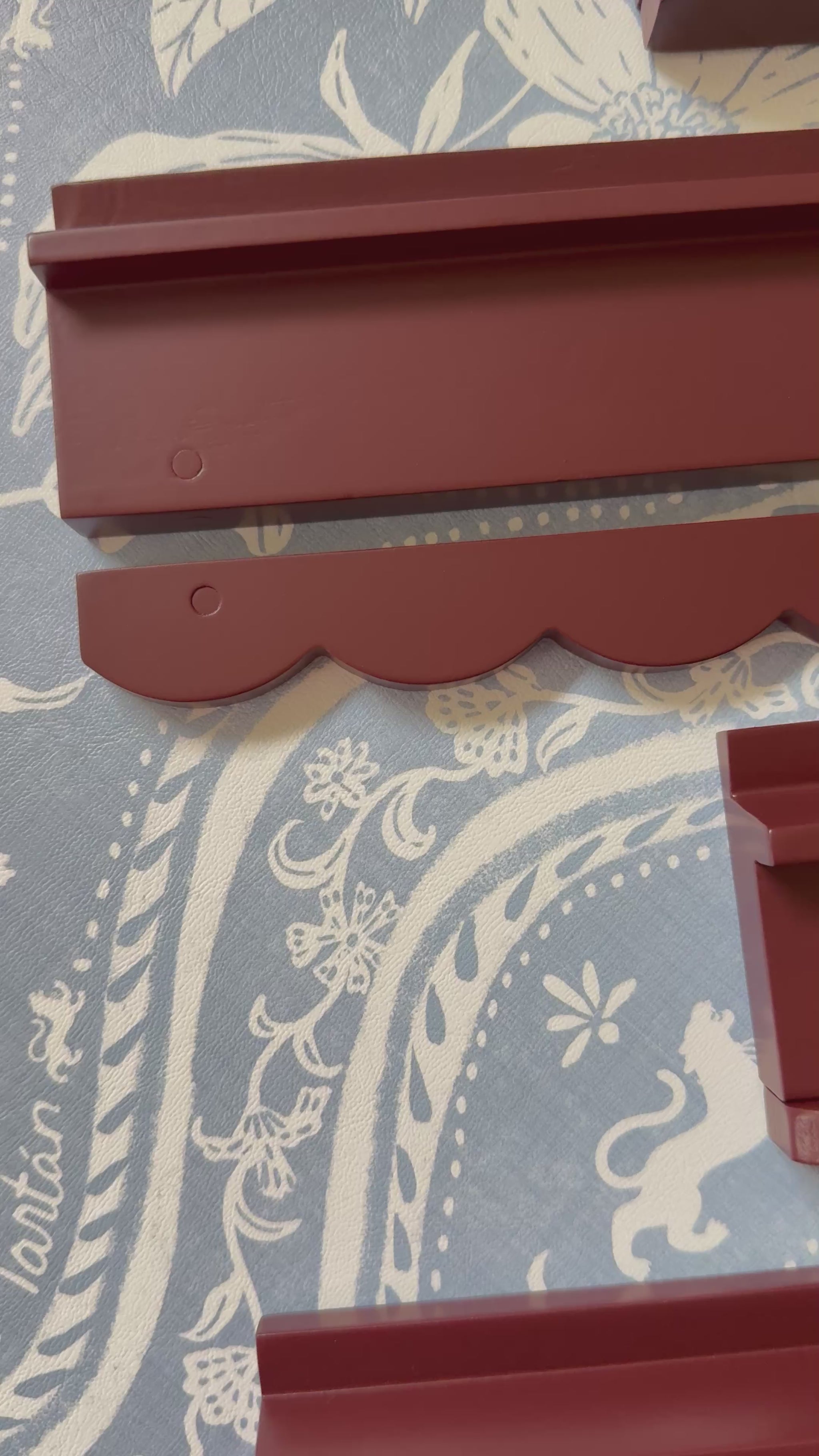 Video of oxblood wooden mahjong racks with scalloped pushers on blue and white fabric