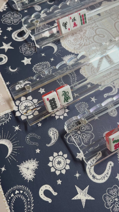 Video of tiles in clear scalloped acrylic racks on a navy bandana-print mat
