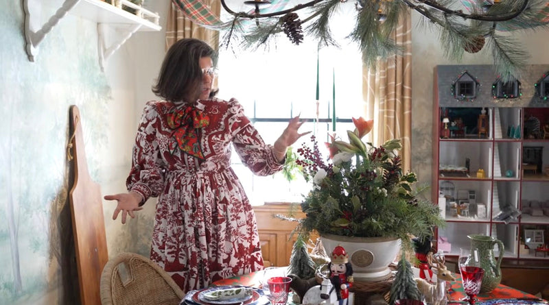 Homeworthy feature: a woman in a printed dress in a room dressed with winter greenery